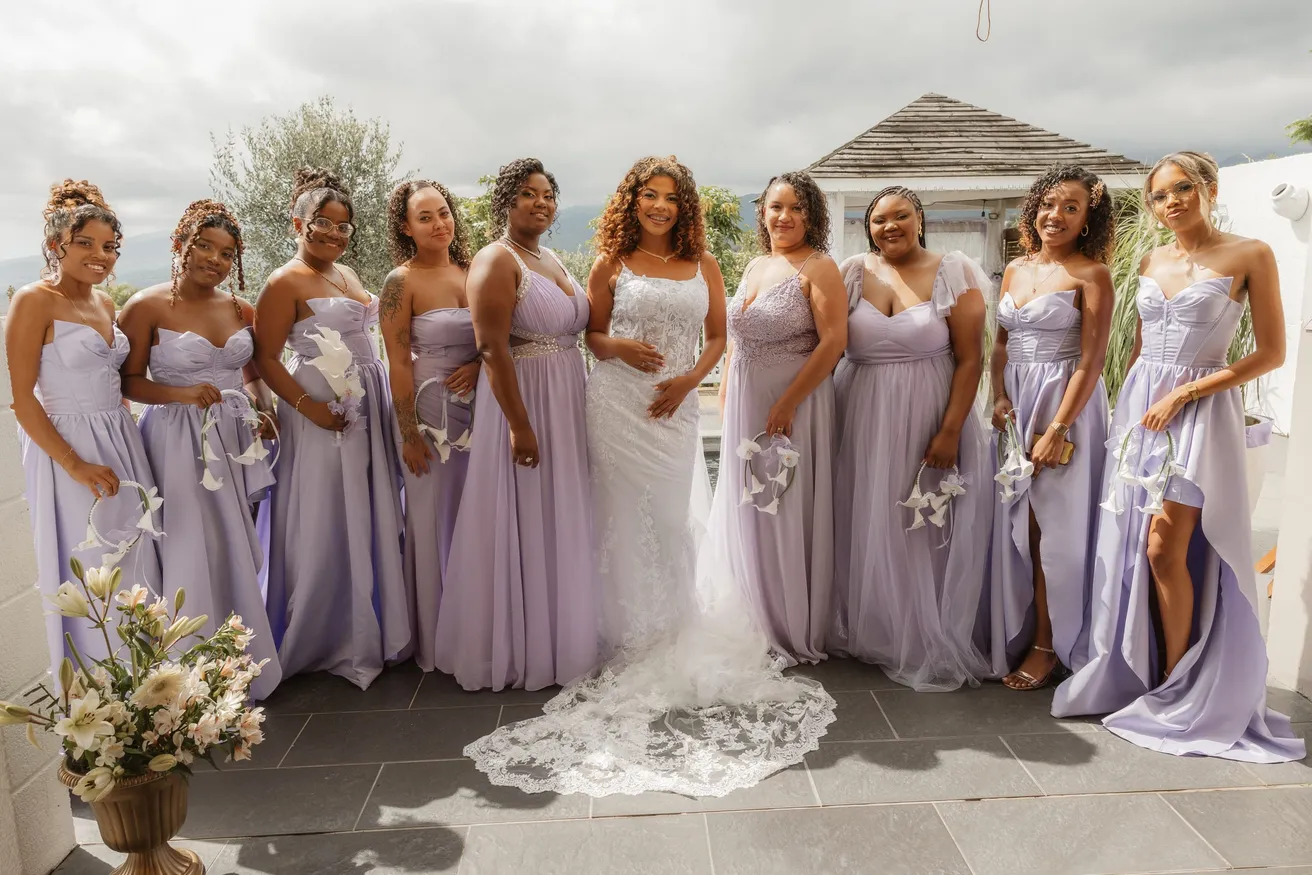 Les demoiselles d’honneur en robes lilas entourent la mariée, bouquets à la main