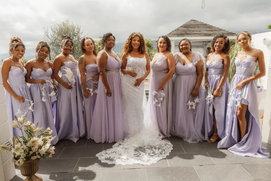 Les demoiselles d’honneur en robes lilas entourent la mariée, bouquets à la main