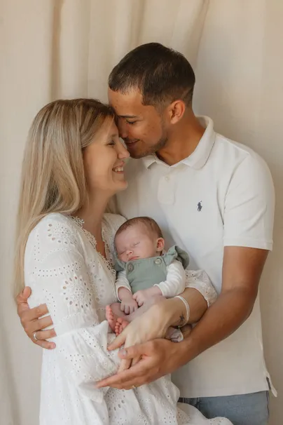Les parents front contre front au-dessus de leur bébé endormi