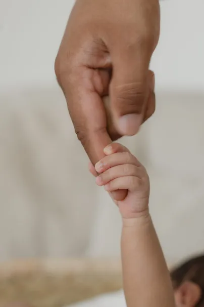 La main d’un adulte tient le poignet minuscule d’un nouveau-né